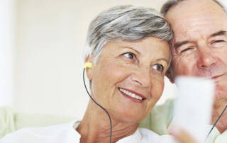Closeup of happy mature couple listening music together at home