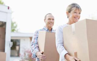 Couple carrying moving boxes