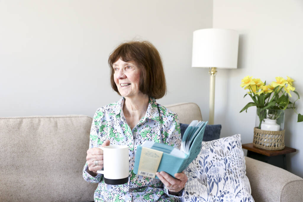 Woman with book and mug in her hands