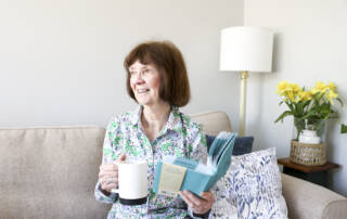 Woman with book and mug in her hands
